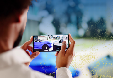 A man viewing a car accident video on his smartphone