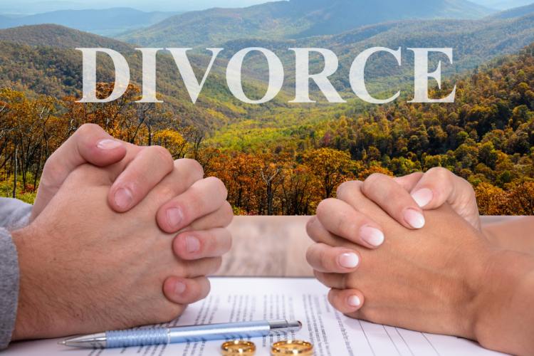 Two pairs of hands clasped over divorce papers and wedding rings
